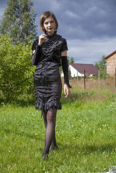 Skinny amateur Lady Phanthom doffs a dress and hose to pose nude in a yard