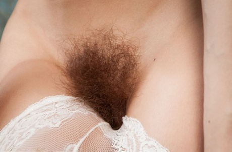Skinny young girl Dennie sets her full bush free while going nude on a bench